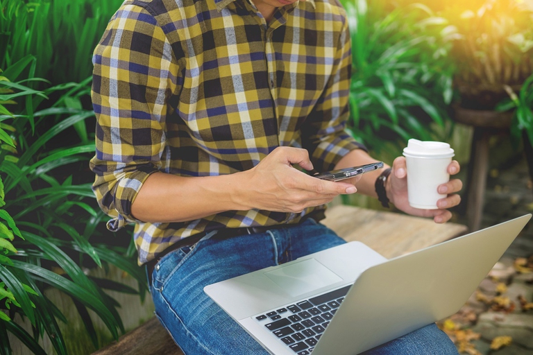 Uomo con pc al lavoro in un parco pubblico