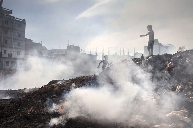 Bambini giocano in una discarica in Bangladesh