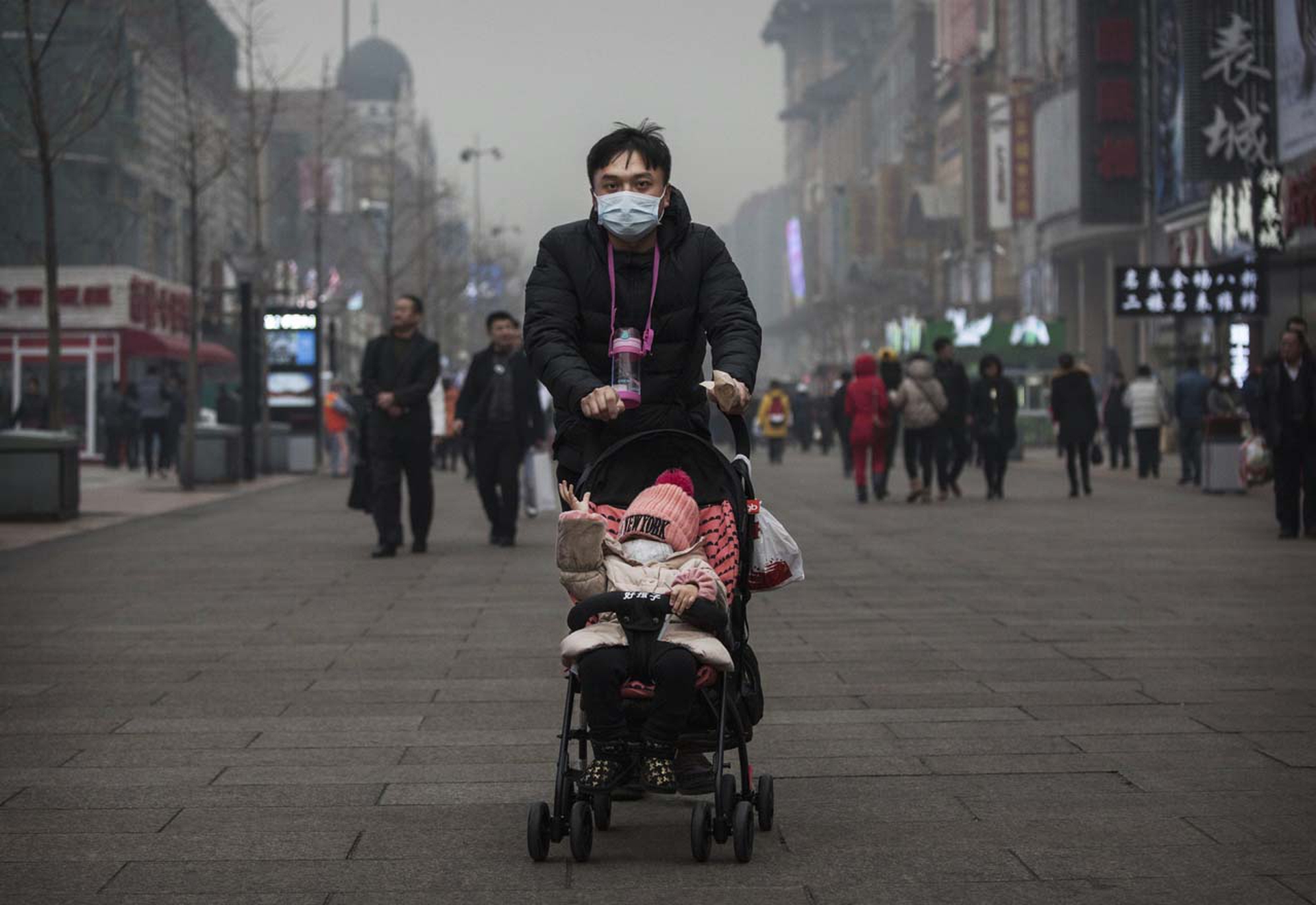 Padre e figlio con maschera anti-smog, Pechino, Cina, dicembre 2015