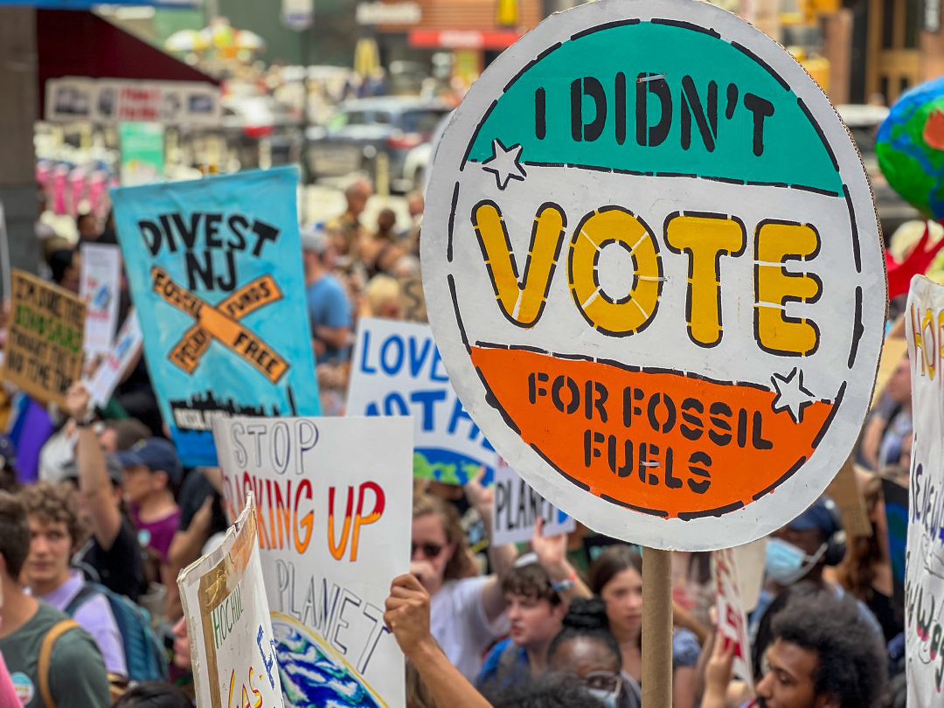 Protesters hold placards against fossil fuel expansion.