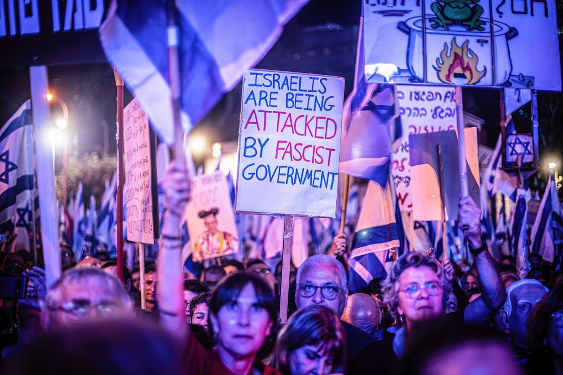 Israeli pro democracy protester holds a placard expressing