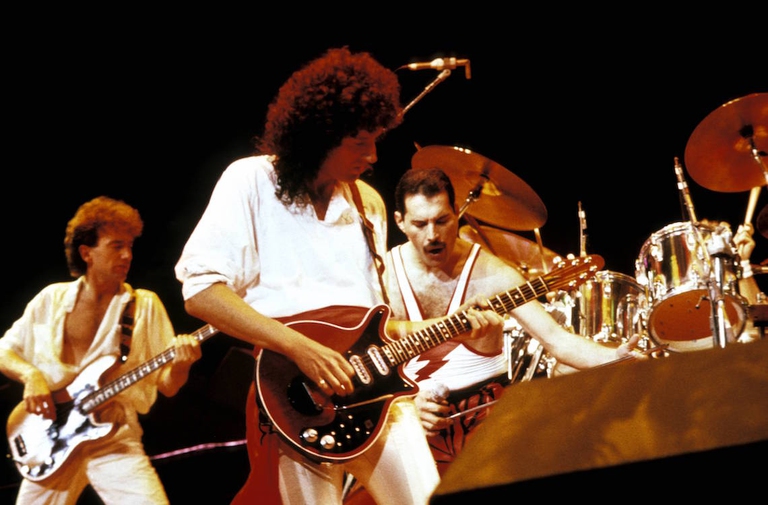 I Queen suonano sul palco durante un live.