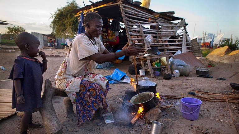 Una madre accende il fuoco e cucina per la sua famiglia, Photo by Paula Bronstein/Getty Images