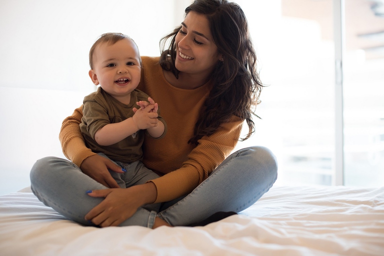 Una giovane mamma e il suo bambino sul letto